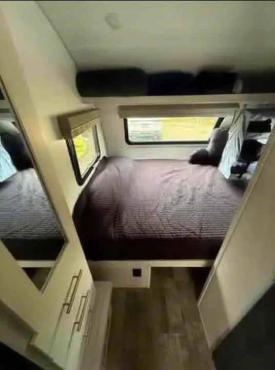 RV rental bedroom with a comfy dark bed, two windows, overhead storage, and mirrored wardrobe for your travels.. R-Pod Hood River Edition 2021