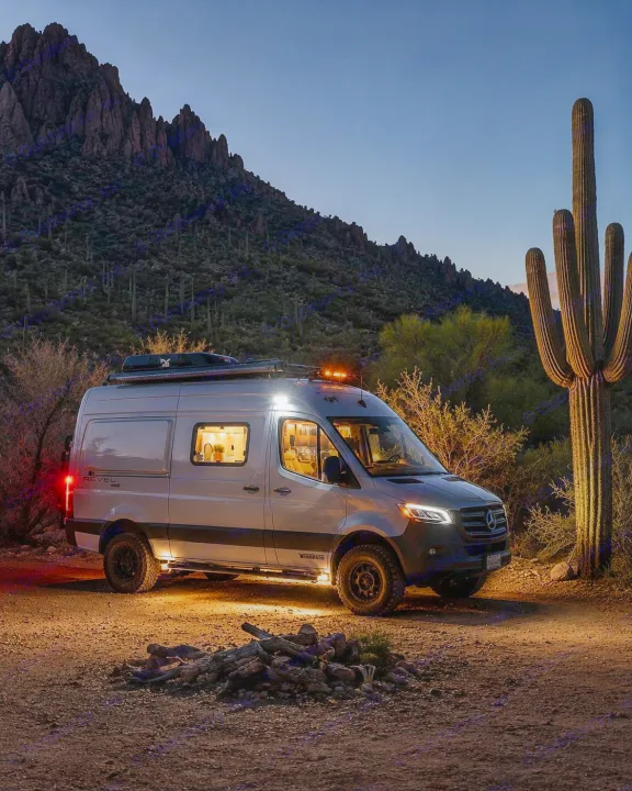 An illuminated Winnebago Revel camper van sits in a desert scene at night, ready for your next RV rental adventure.. Winnebago Revel 2021