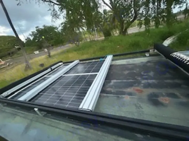 Solar panels on an rv rental roof for sustainable travel. Provides off-grid power, visible from a top-down perspective.. Ford Excursion 2000