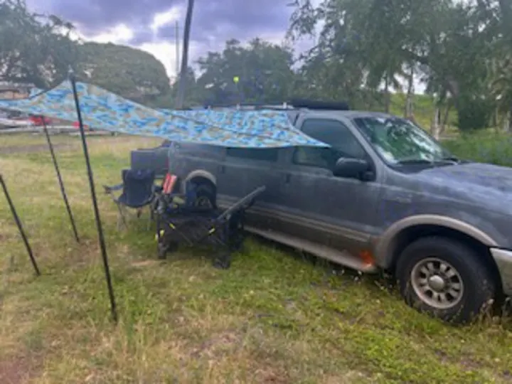 This SUV, set up with an awning & camping chairs, is perfect for outdoor adventure, even without an RV rental.. Ford Excursion 2000
