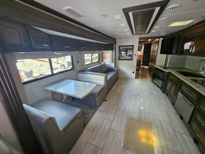 Spacious modern RV rental interior, featuring a dinette, sofa, kitchen, and ample storage.. Forest River Berkshire XLT 2024