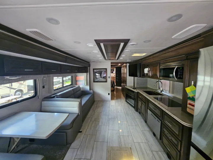 Spacious rv rental interior showcasing a modern kitchen, comfortable dinette, and living area with a sofa.. Forest River Berkshire XLT 2024