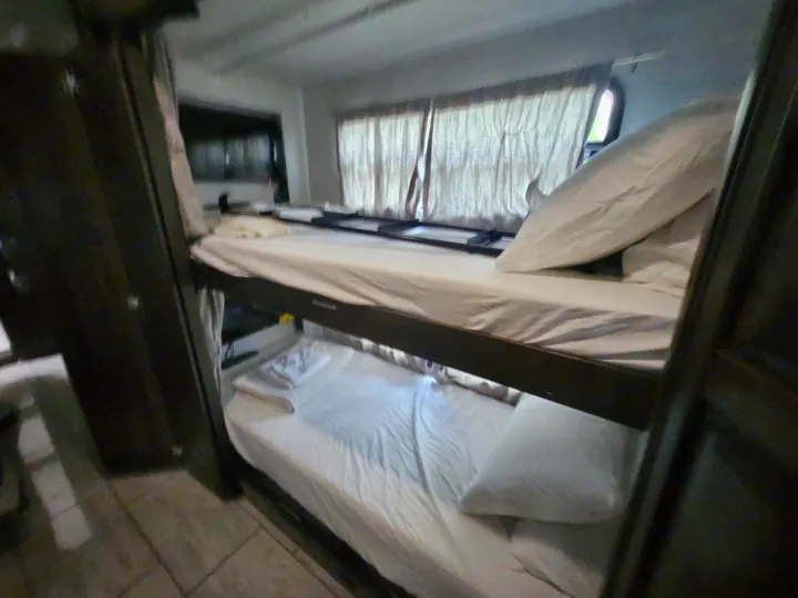 Cozy RV rental bunk beds: fresh white linens provide compact sleeping accommodations for your adventure.. Forest River Berkshire XLT 2024