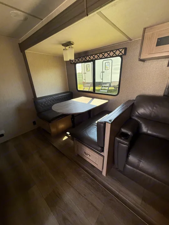 Spacious RV rental interior with dinette, comfy recliners, and wood-look flooring. Perfect for your next adventure!. Coachmen Other 2021