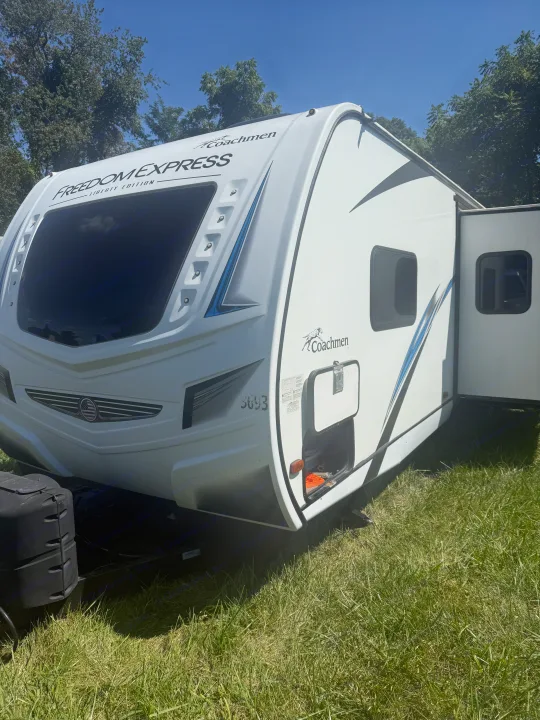 White Coachmen Freedom Express RV rental parked on sunny grass. Ideal for your next outdoor travel adventure!. Coachmen Other 2021