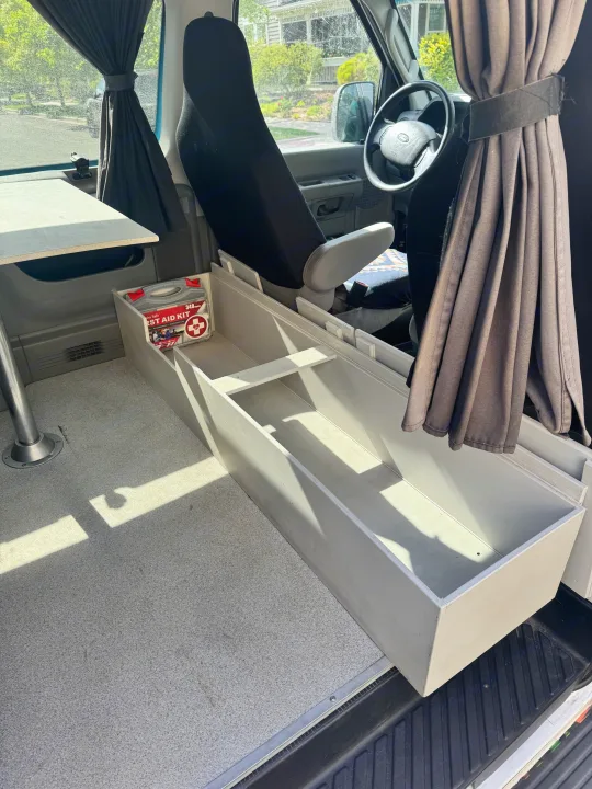 RV rental camper van interior: Custom storage, table, privacy curtains, and a first aid kit for safe travels.. Ford Econoline 150 2012