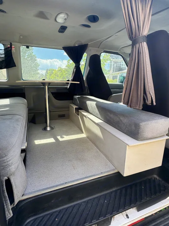 Bright, functional camper van interior ready for your rv rental. Features a dining table, cozy seating, and smart storage.. Ford Econoline 150 2012