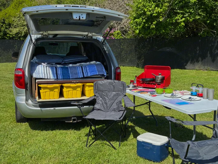 Minivan micro-camper with bed, storage, and outdoor kitchen setup, offering a budget-friendly alternative to RV rental.. Dodge Grand Caravan 2005