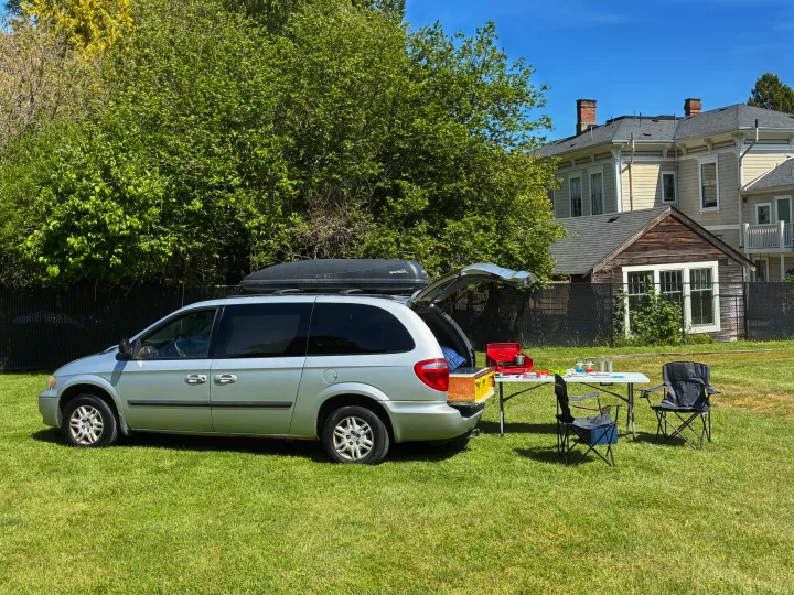 Minivan camping setup: open hatch reveals a portable kitchen & gear for an RV rental adventure.. Dodge Grand Caravan 2005
