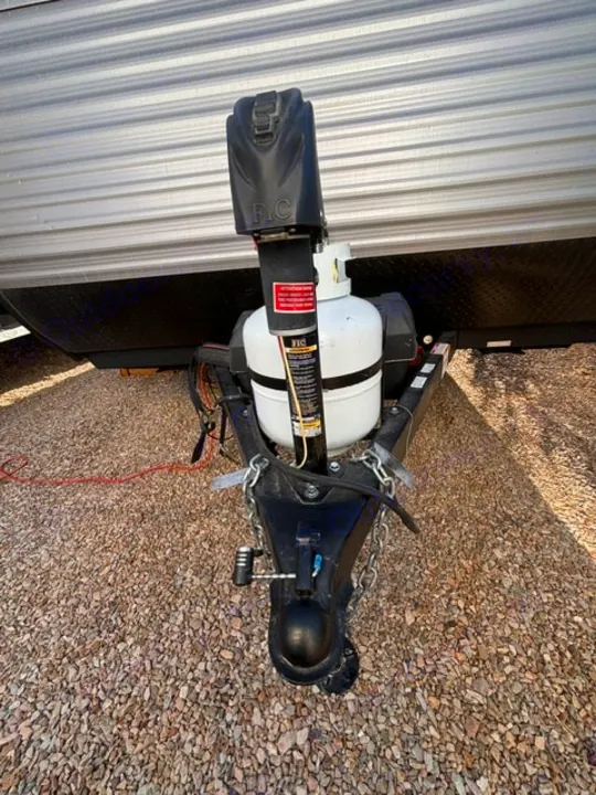 Travel trailer hitch for RV rental: electric jack, propane tank, coupler, and safety chains shown.. Dutchmen Coleman Lantern LT 2024