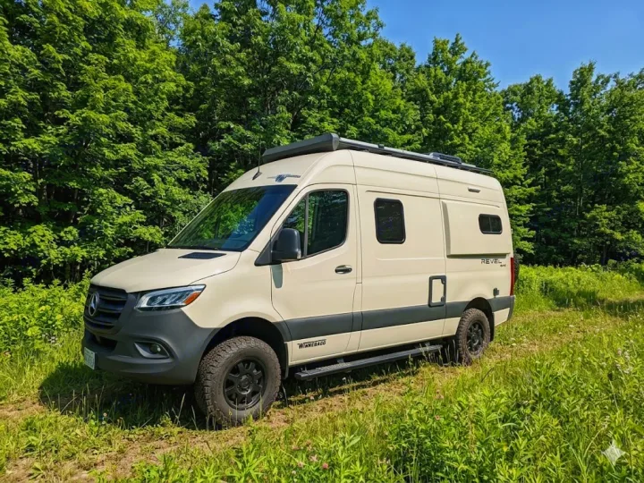 Adventure-ready Winnebago Revel 4x4 camper van, perfect for your next rv rental adventure, parked in a sunny clearing.. Winnebago Revel 2023