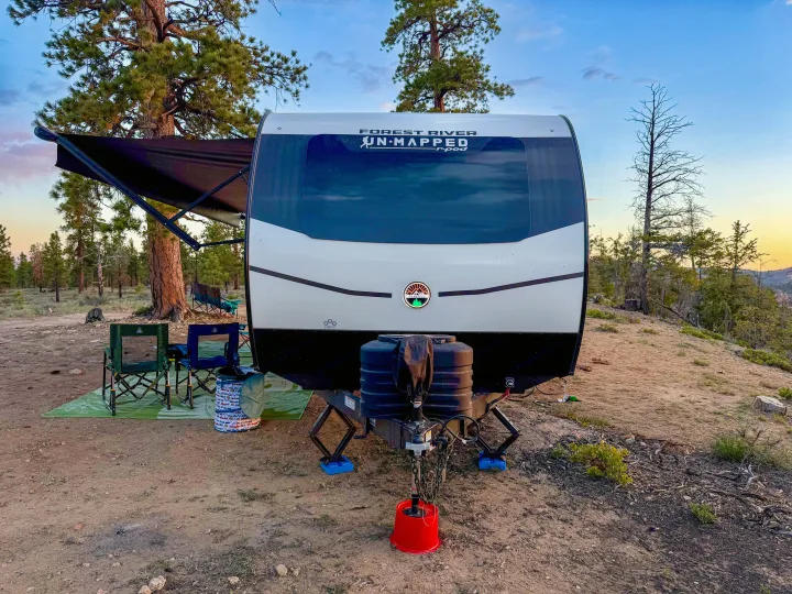 RV rental: Forest River r-pod travel trailer at a scenic, tree-lined campsite with awning extended and chairs out.. Forest River Unmapped 2026