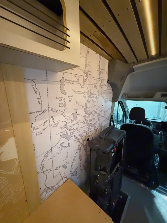 Detailed map of the Allagash region displayed in an rv rental van interior with wooden ceiling, storage, and front seat.. Ford Transit 2025