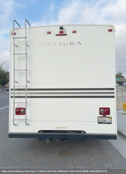 Rear view of an Entegra RV rental, featuring a ladder, California license plate 8GBN572, and backup camera. Ready for adventure.. Entegra Coach Odyssey 2019