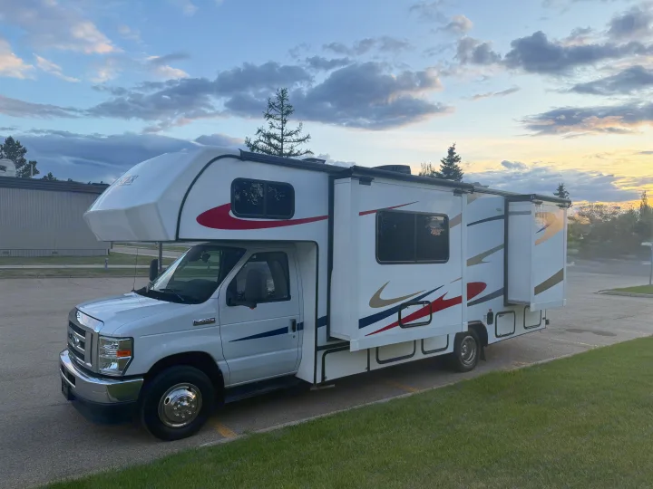This white Class C RV rental with extended slide-outs is parked on asphalt, ready for your next motorhome adventure or camping trip.. Forester 2501CD 2023