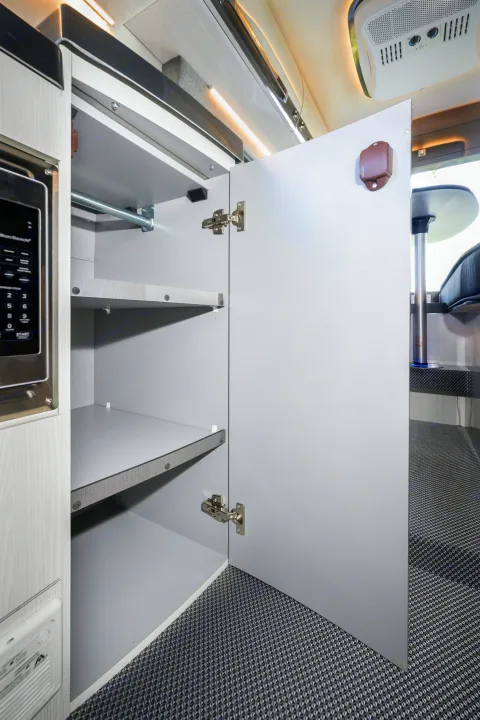RV rental interior: open cabinet with shelves, microwave, and ceiling AC unit. Modern design with dining space.. Other Gala Montecarlo 2025