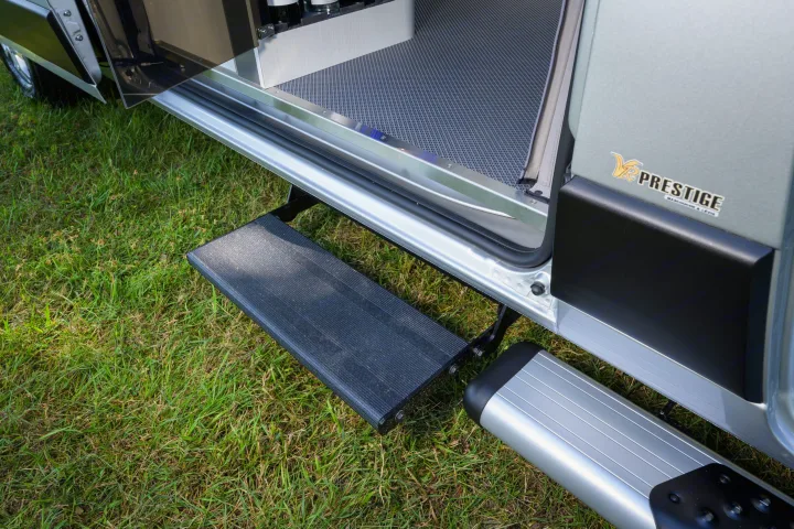 An RV rental with an accessible automatic step extended, showing easy entry into the Prestige van parked on grass.. Other Gala Montecarlo 2025
