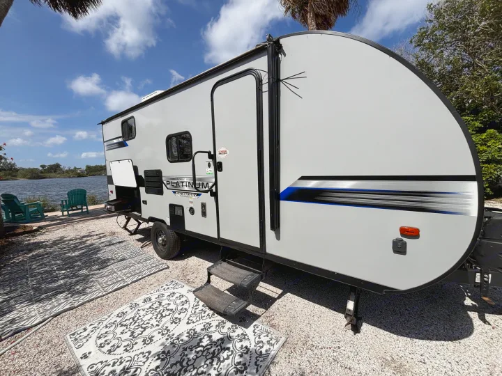 Relax by the water in this modern rv rental, a Forest River Platinum Salem FSX travel trailer, with outdoor rugs and chairs.. Forest River Salem FSX PLATINUM 2020