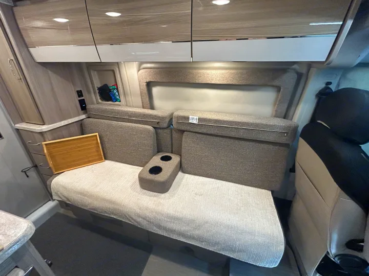 RV rental interior featuring a cozy dinette with cushions, cup holders, and overhead storage, ready for travel.. Thor Scope 2022