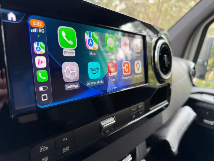 RV rental's Apple CarPlay infotainment system displaying navigation, music, and a Holy Bible app, with 5G connectivity.. Coachmen Prism 2026