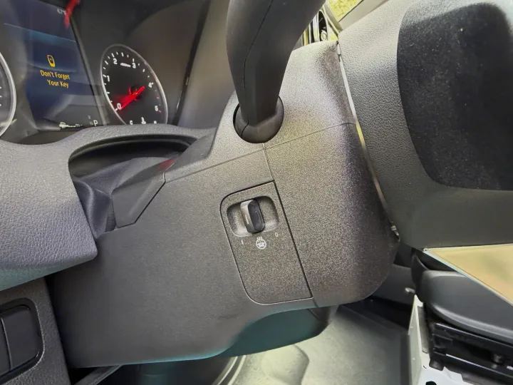 An RV rental interior, showing a heated steering wheel switch and a "Don't Forget Your Key" reminder on the dashboard display.. Coachmen Prism 2026