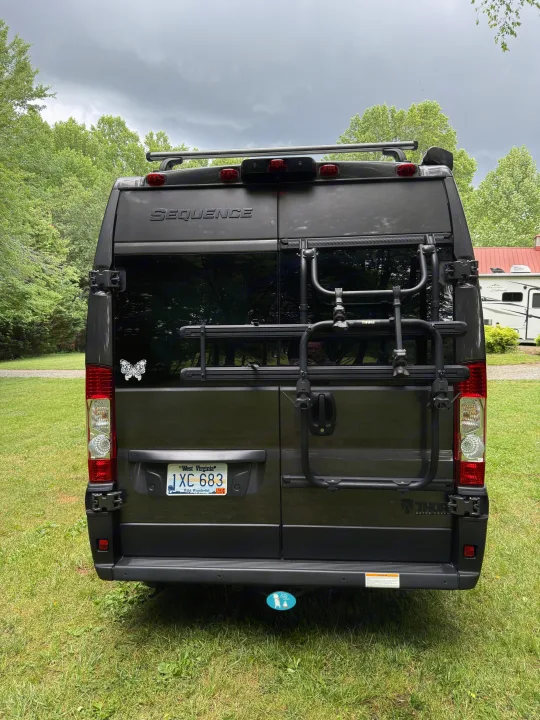Rear view of a gray Thor Motor Coach Sequence camper van with a WV plate & Thule bike rack, perfect for your rv rental.. Thor Sequence 2022