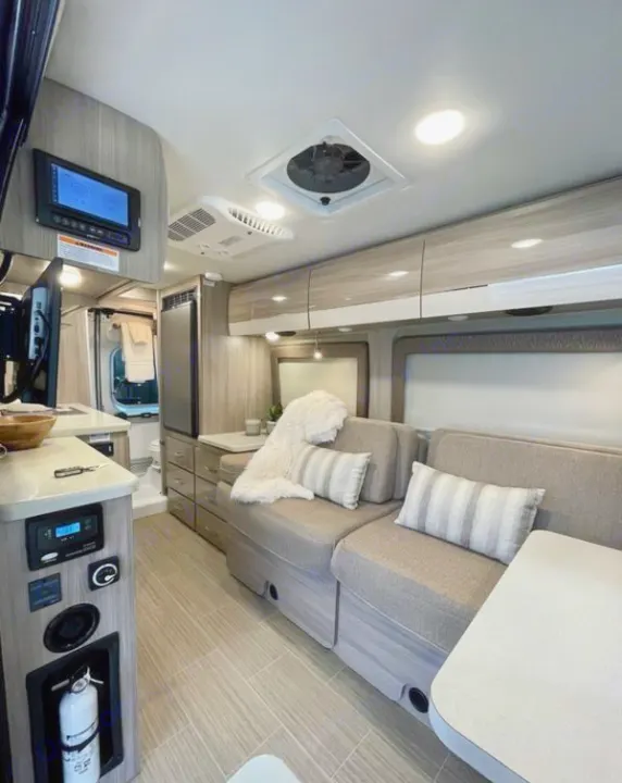 Explore this modern rv rental interior with cozy seating, kitchenette, ceiling fan, and easy-to-use controls.. Thor Sequence 2022