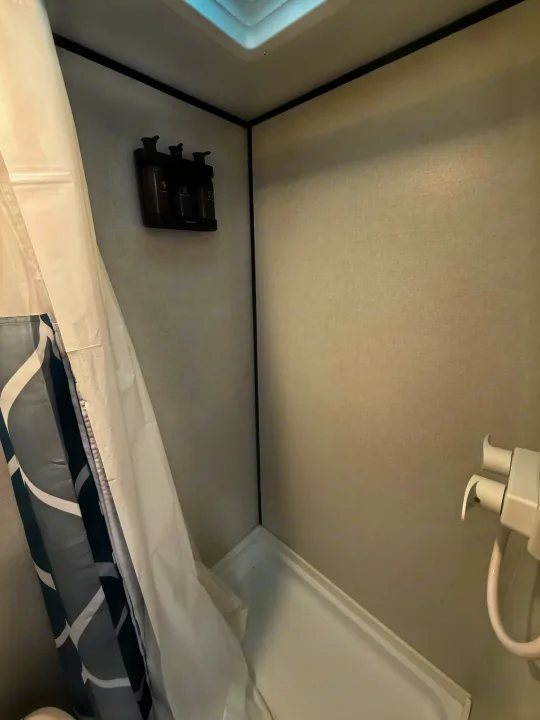 RV rental shower with convenient wall-mounted shampoo, conditioner, and body wash dispensers.. Keystone RV Coleman 13B 2026