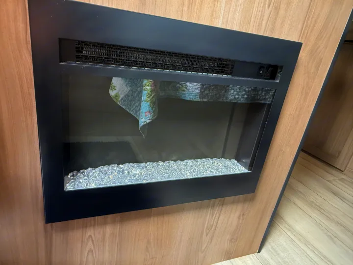 Experience comfort in this RV rental! Features a built-in electric fireplace with a black frame and decorative crystal media.. Keystone RV Coleman 13B 2026