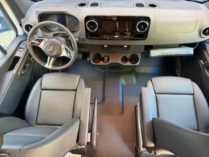 Step into this RV rental's modern Mercedes-Benz van cockpit with a sleek dashboard, steering wheel, and comfortable front seats.. Coachmen Prism 2026