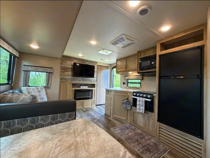Cozy RV rental interior showcasing a modern kitchen, dining area, comfy seating, and entertainment for your trips.. Coachmen Catalina Legacy 2022