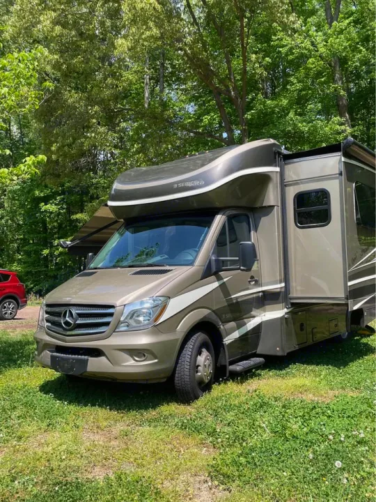 Tan Mercedes-Benz RV rental parked on green grass with trees in the background. Perfect for your next outdoor adventure.. Isata 3 2017