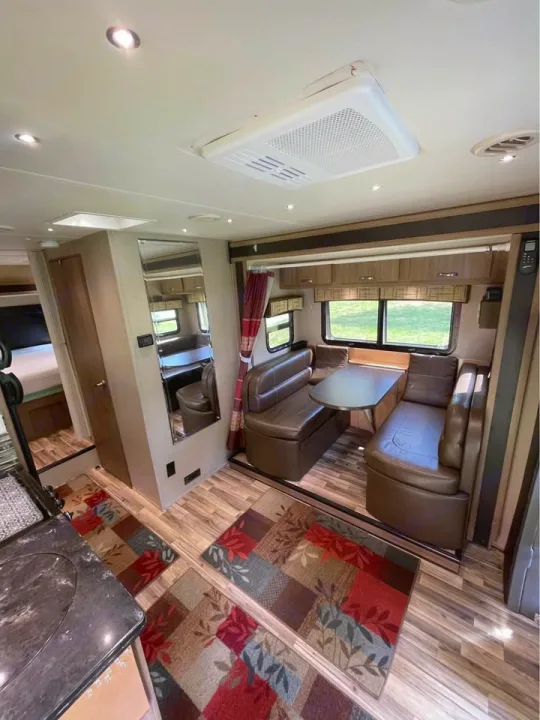 Cozy RV rental interior with a spacious dinette, patterned rugs, and kitchen counter visible, ready for your travel adventure.. Isata 3 2017