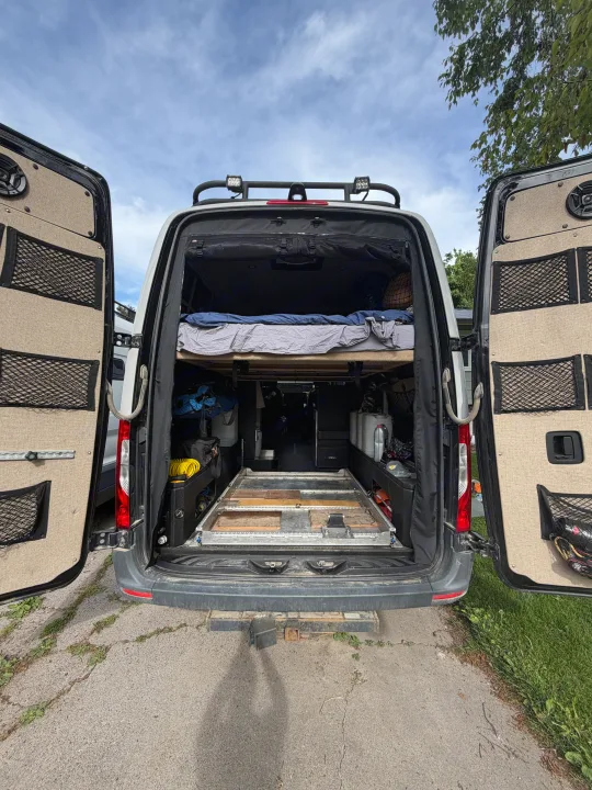 Experience van life with this RV rental: Features a raised bed, organized storage, and a sturdy pull-out platform.. Mercedes Sprinter 2019