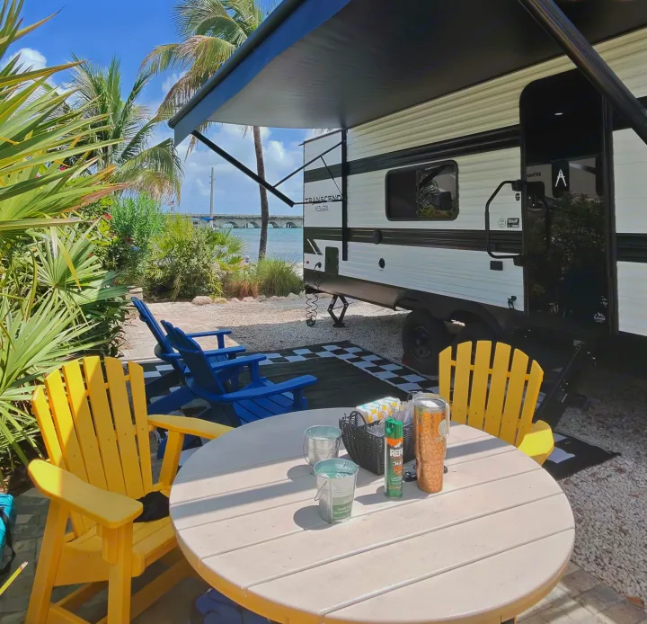 RV rental in a tropical setting with an outdoor patio, Adirondack chairs, and ocean views, ideal for relaxation.. Grand Design Transcend Xplor 2026