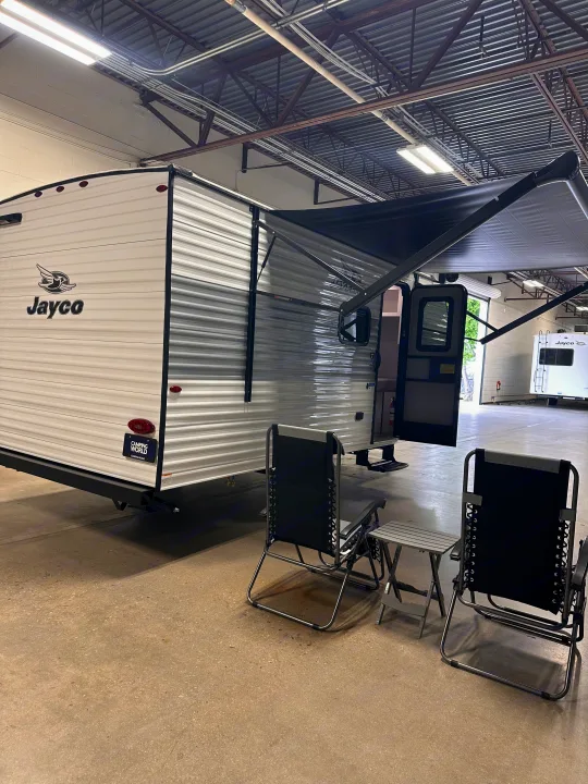 Jayco travel trailer for RV rental with extended awning, camping chairs, and table, ready for your next adventure.. Jayco Jayco 2026