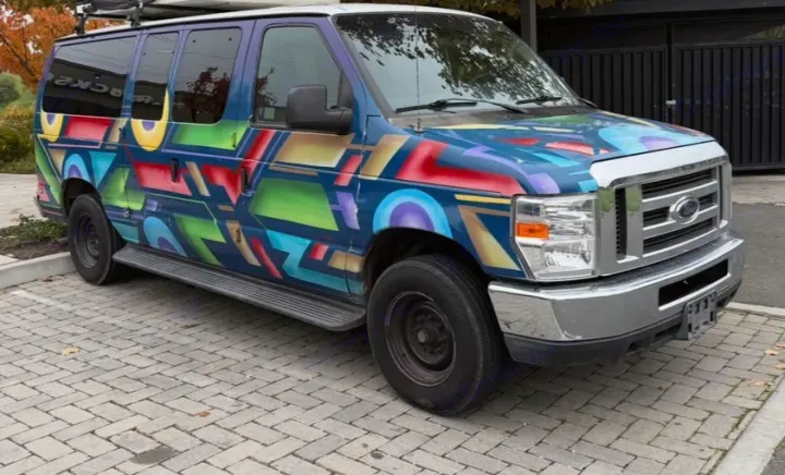 Vibrant, graffiti-painted Ford van, perfect for an rv rental road trip. This custom travel van features a roof rack.. Ford E350 Box Van 2013