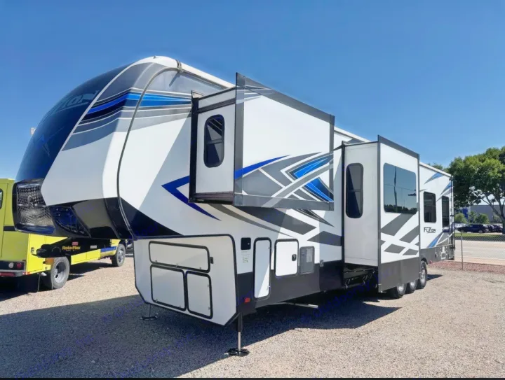 Stunning white, black, and blue fifth-wheel RV rental with extended slide-outs. Ideal for luxury travel & outdoor adventures.. Keystone Fuzion 2020