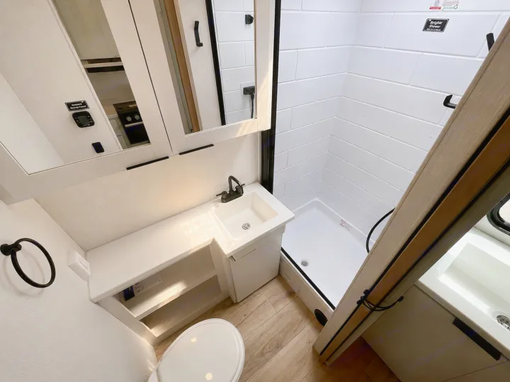 RV rental bathroom with a shower, toilet, and vanity. Clean, modern design for comfortable travels.. Winnebago Thrive 2026