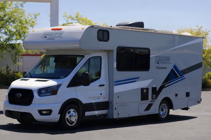 A white and gray Coachmen Cross Trail Class C RV rental, built on a Ford Transit chassis, parked outdoors.. Coachmen Cross Trail 2023