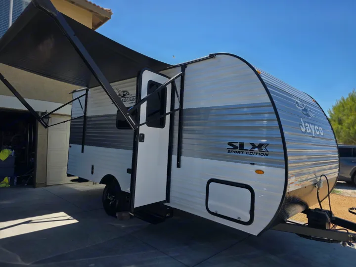 Jayco SLX Sport Edition travel trailer with extended awning, parked on a driveway. Ideal for an RV rental adventure.. Jayco Jayco 2026