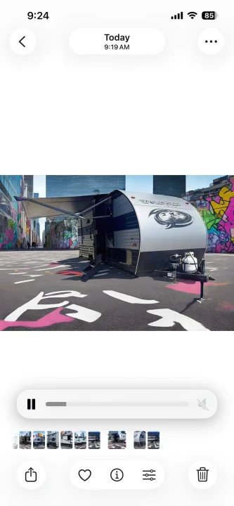 This Wolf Pup travel trailer, ideal for rv rental, is parked on a graffiti-painted urban street with its awning extended.. Forest River Cherokee Wolf Pup 2021