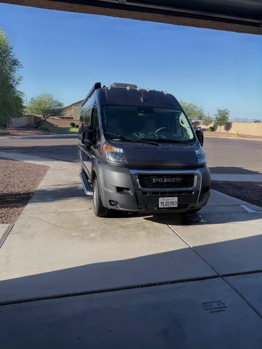 An RV rental, a dark gray Ram ProMaster van with California plate 9LDS983, parked in a sunny driveway. Ready for travel!. Jayco Swift Li 2023