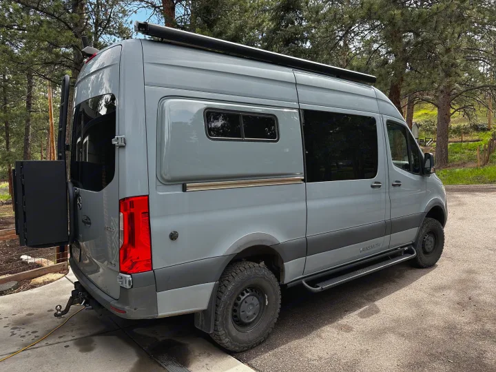 Gray Sprinter **rv rental** by VANSMITH. This adventure van features off-road tires, an awning, and rear storage.. Mercedes-Benz Sprinter 2020
