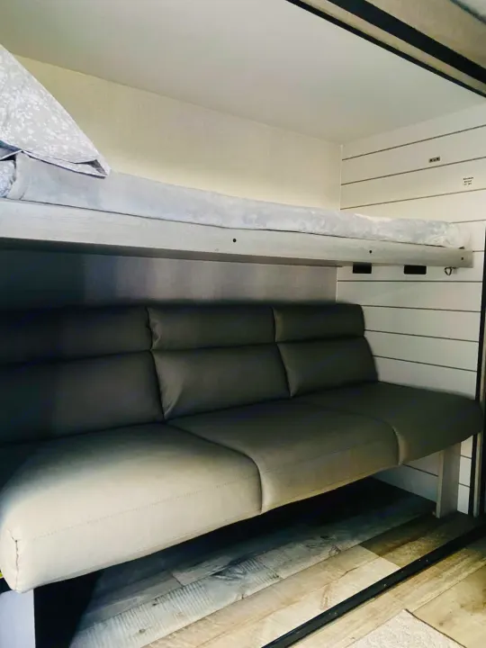 RV rental interior: A compact sleeping and lounging space with a bunk bed over a comfortable sofa.. Crossroads RV Sunset Trail Super Lite 2025