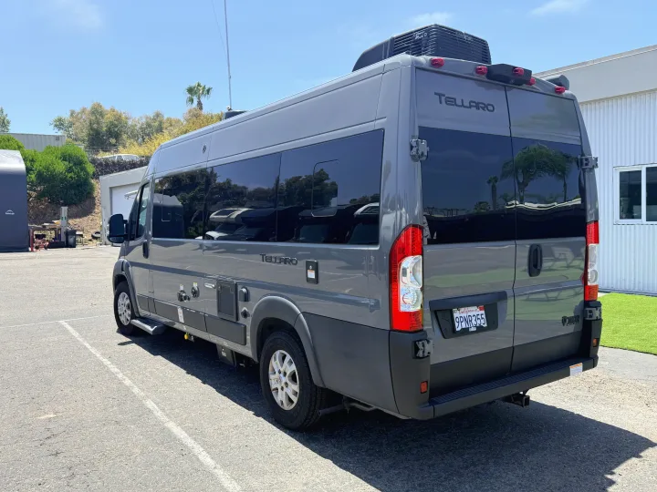 Gray Tellaro RV rental van parked outdoors on asphalt, shown from the rear-side. Ready for travel adventures in this camper van.. Thor Tellaro 2024