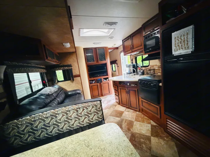 This inviting rv rental offers a full kitchen with oven, microwave, and fridge, plus a comfortable sofa and dining area.. Crossroads RV Zinger 2014