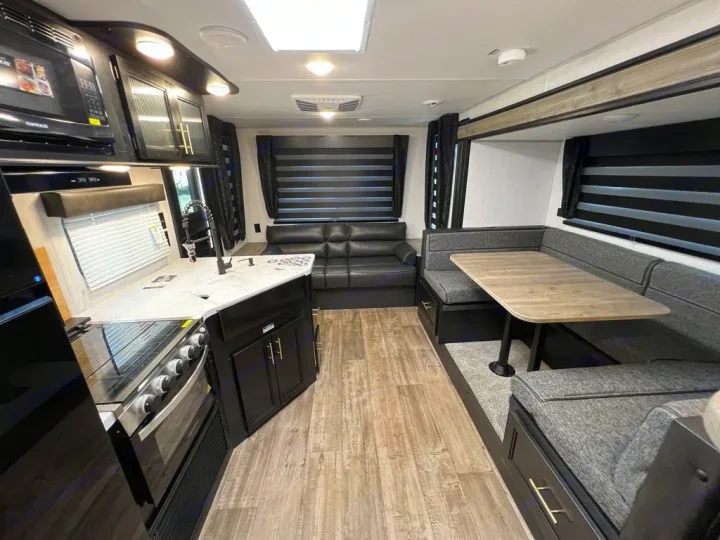 RV rental: Modern kitchen with stove/sink, U-shaped dinette, & sofa. Stylish and functional interior.. Forest River Cherokee Grey Wolf 2022