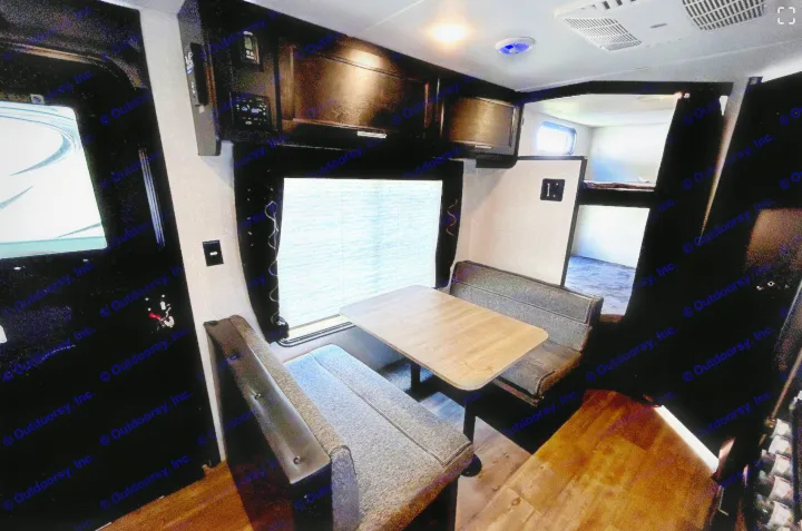 RV rental interior featuring a dinette, overhead cabinets, and bunk beds, offering comfort and convenience.. Forest River Cherokee Grey Wolf 2022