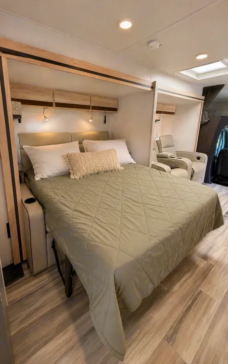 Relax in this comfortable RV rental bedroom, featuring a large bed, overhead storage, reading lights, and plush recliners.. Forest River Sunseeker MBS 2022